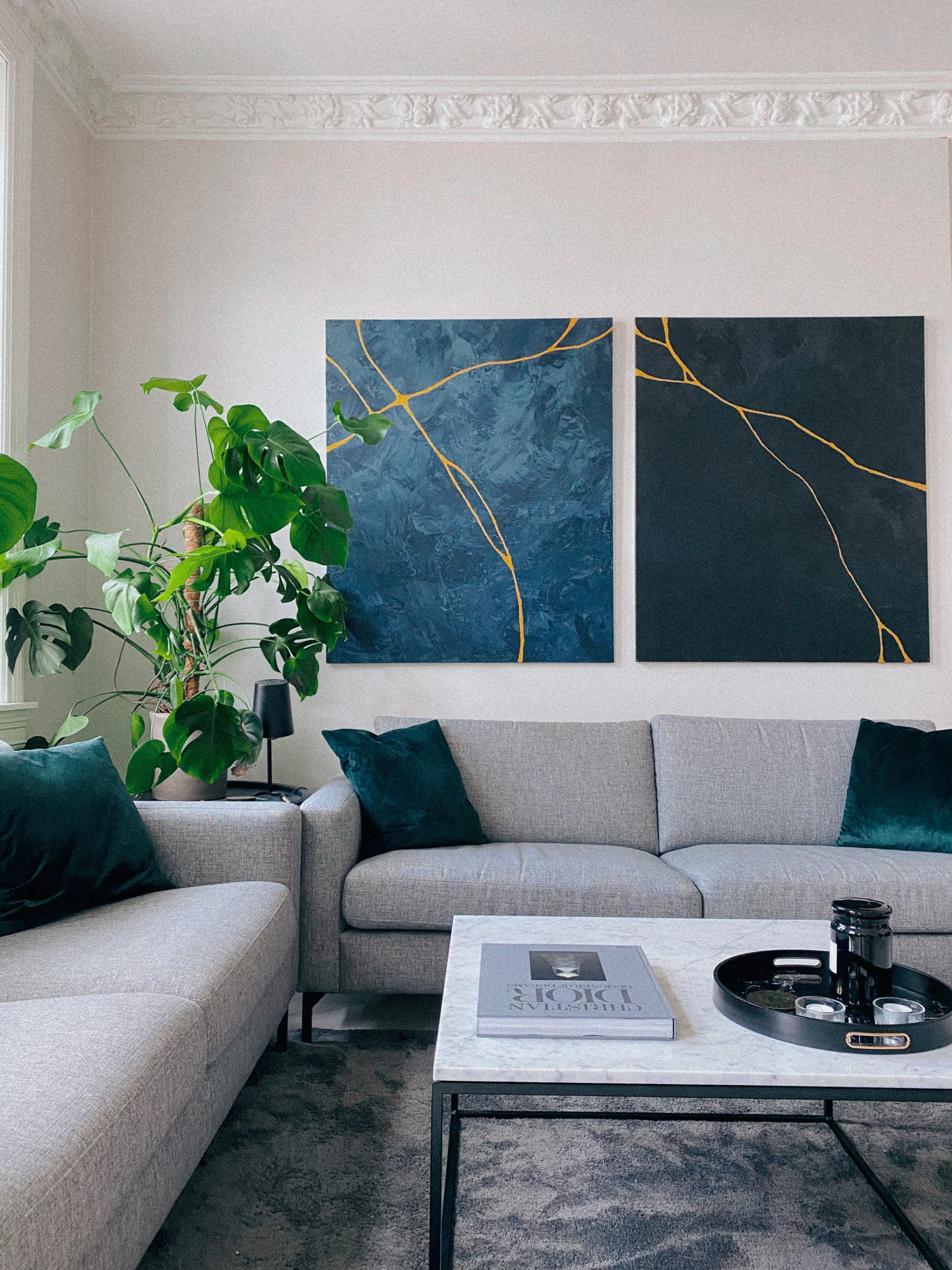 Blue abstract diptych paintings with gold kintsugi lines in modern living room